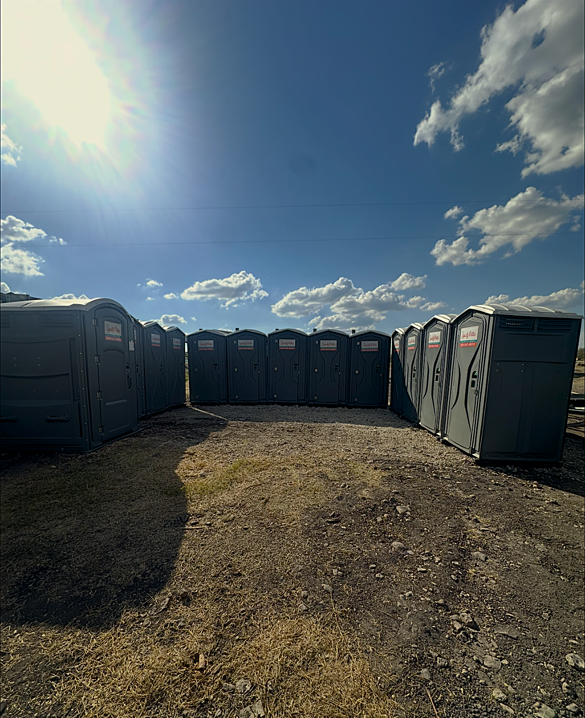 13 port-a-potties lined in a rectangle